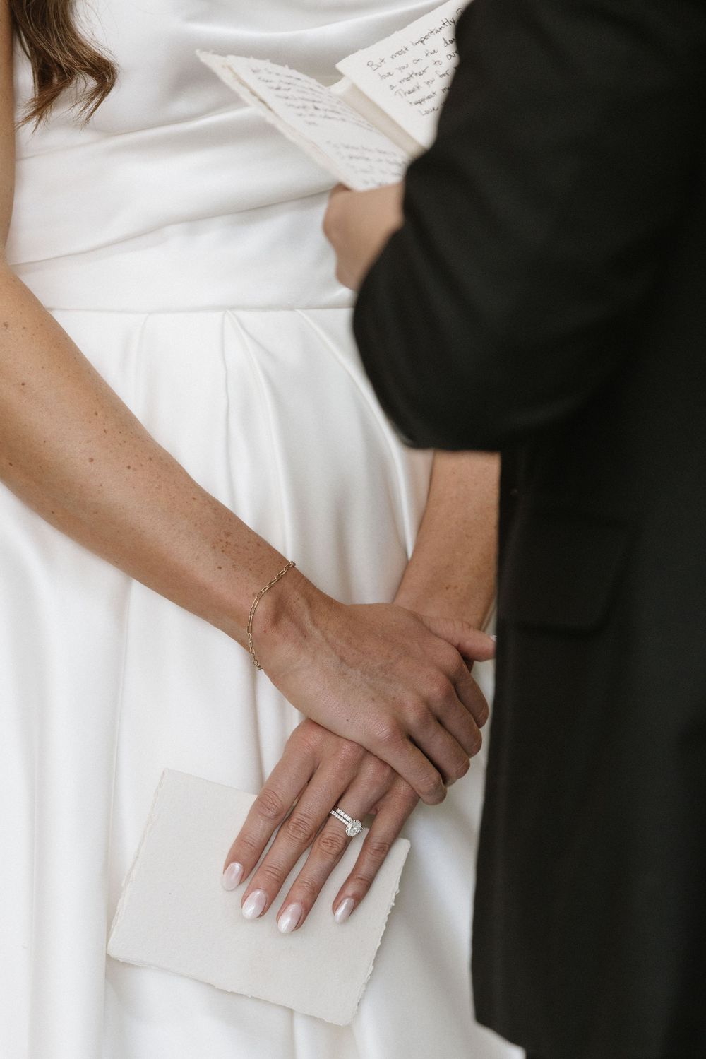Close-up of hands holding letter during wedding ceremony.