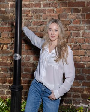 Natural light outdoor portrait of a woman against a historic brick wall in Downtown Charleston, SC.