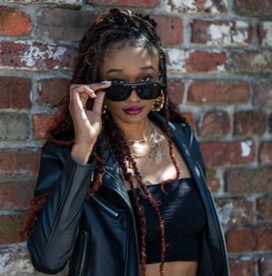 Urban fashion portrait of a woman wearing sunglasses in Downtown Charleston’s historic district.