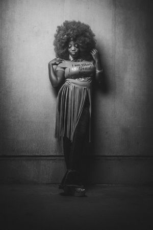 A dramatic black and white photo series showing a figure in a striped dress against a textured wall creating moody pose in Charleston, SC