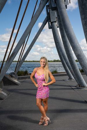 Pink floral romper worn against architectural backdrop of metal beams with water view at Riverfront Park, Charleston, SC
