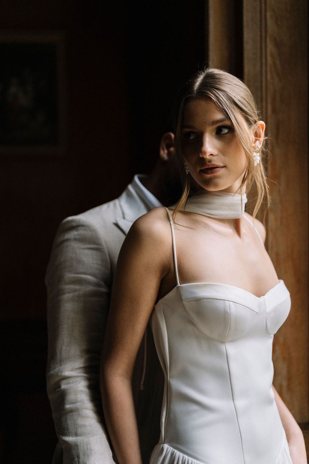 A series of artistic bridal portraits showing a woman in a white wedding dress against a dark rustic background.