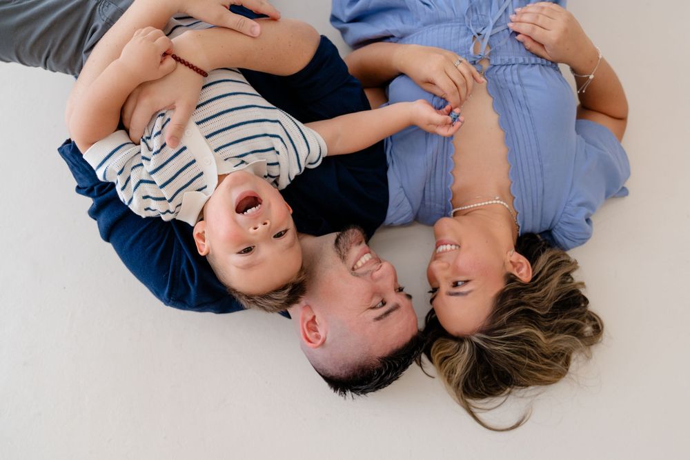 A collection of candid family photos showing joyful moments while lying down together.
