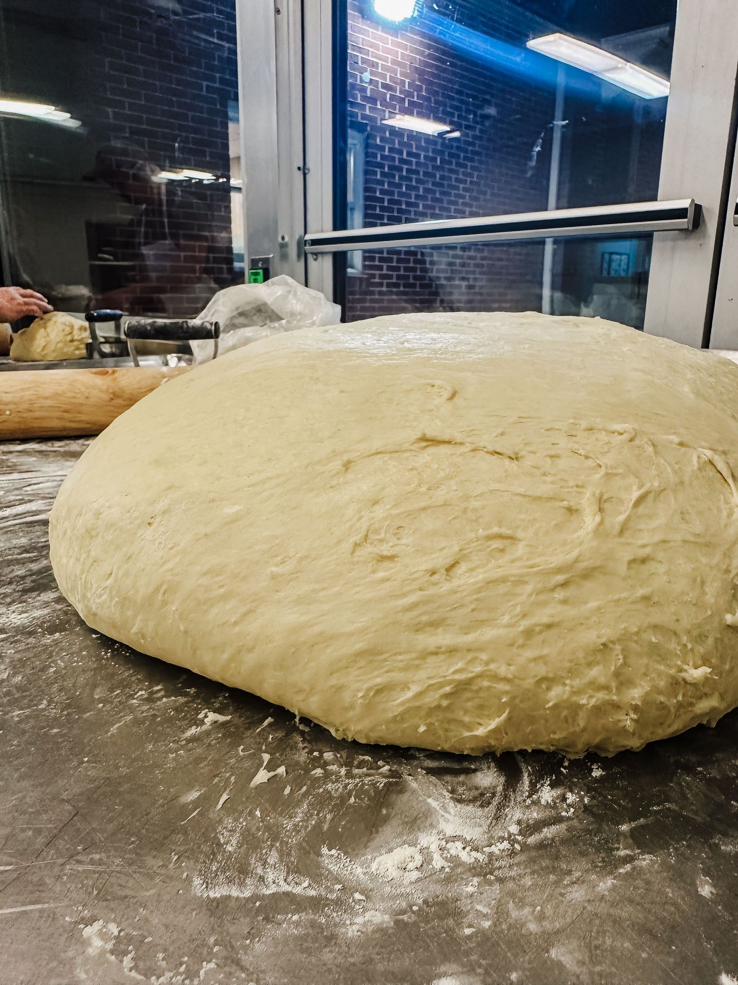 A sequence showing bread dough rising and expanding on a floured surface over time.