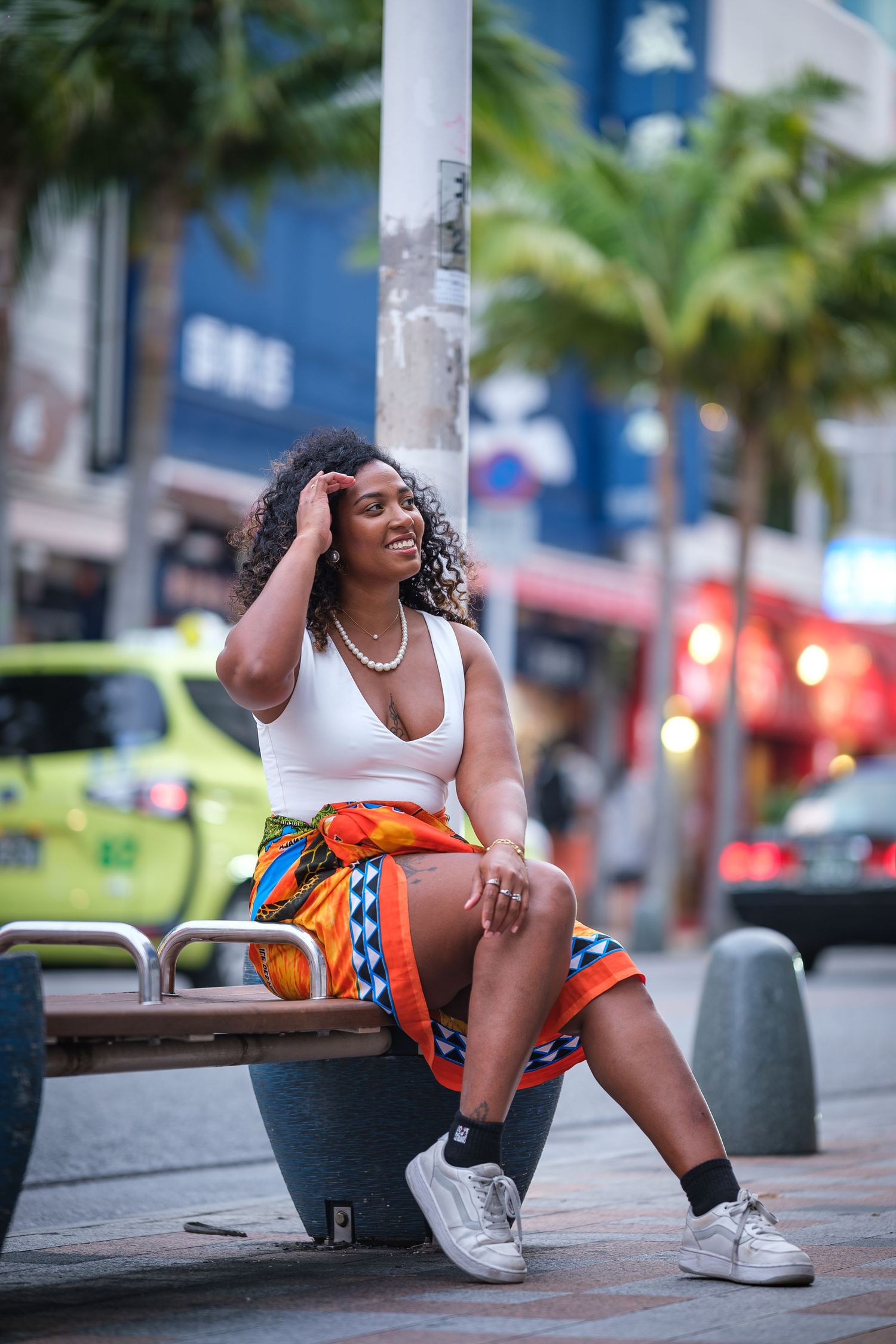 Woman in athletic wear and sneakers strikes dynamic dance poses on an urban street.