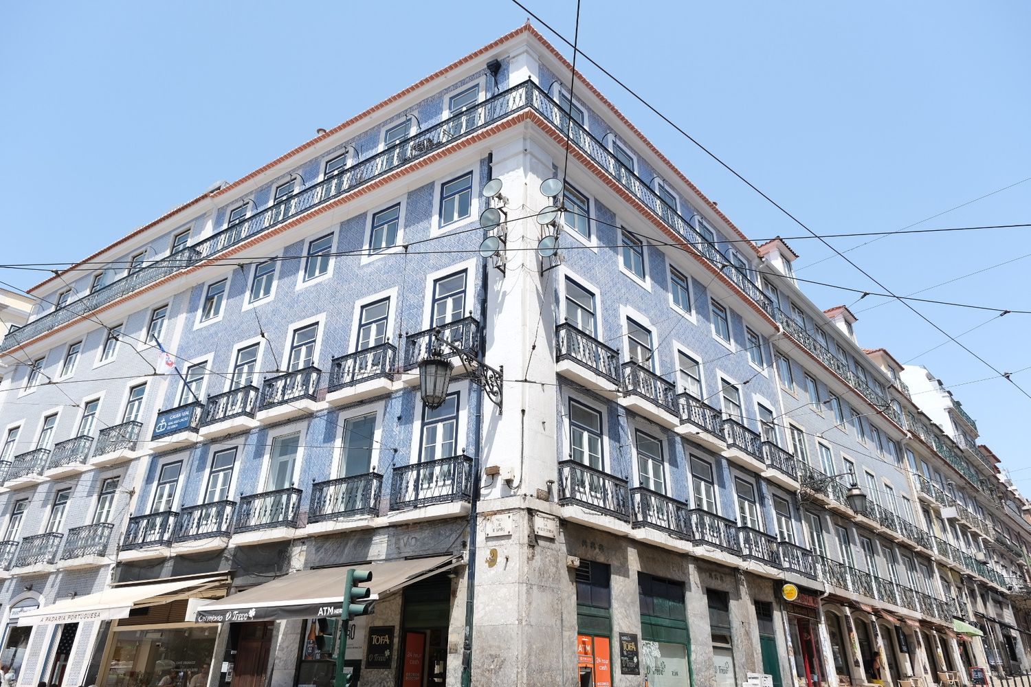 Large blue azulejo tile-covered corner building with balconies in downtown Lisbon, Portugal.