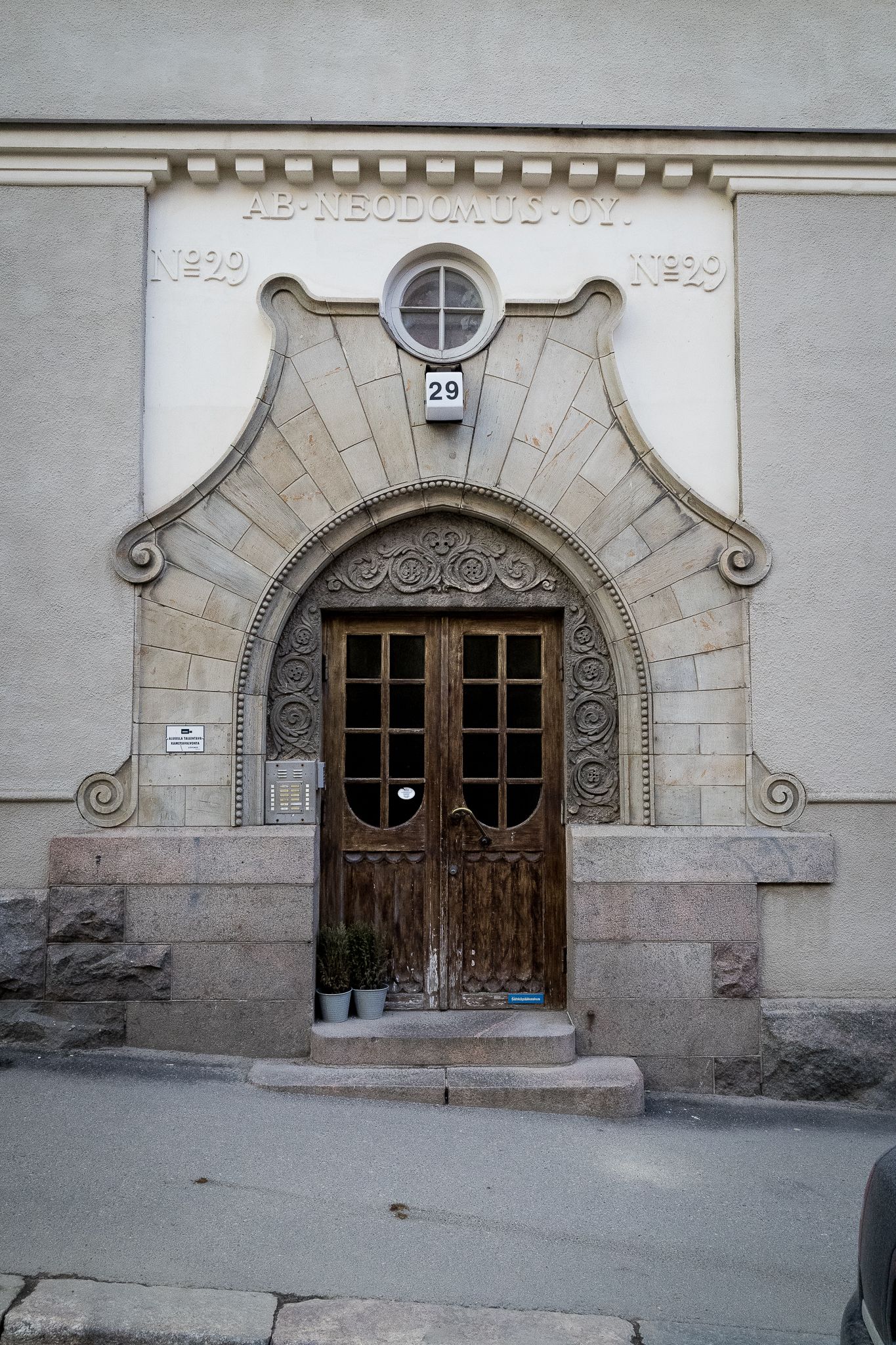 Ornate Art Nouveau building entrance with decorative stone arch, intricate ironwork double doors, and number 29 facade detail.