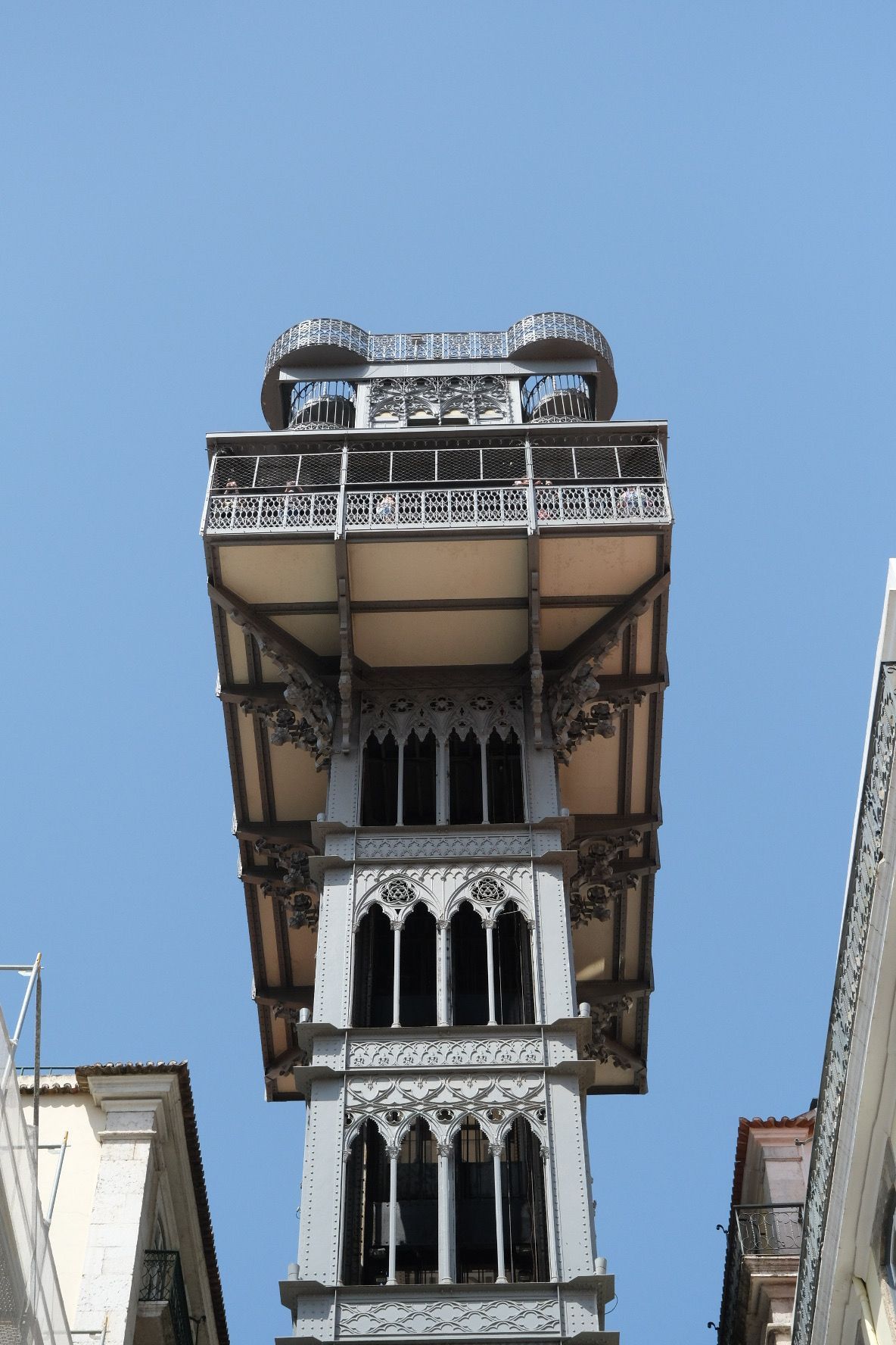 Historic Santa Justa Lift iron elevator tower with Gothic details against clear blue sky in Lisbon.