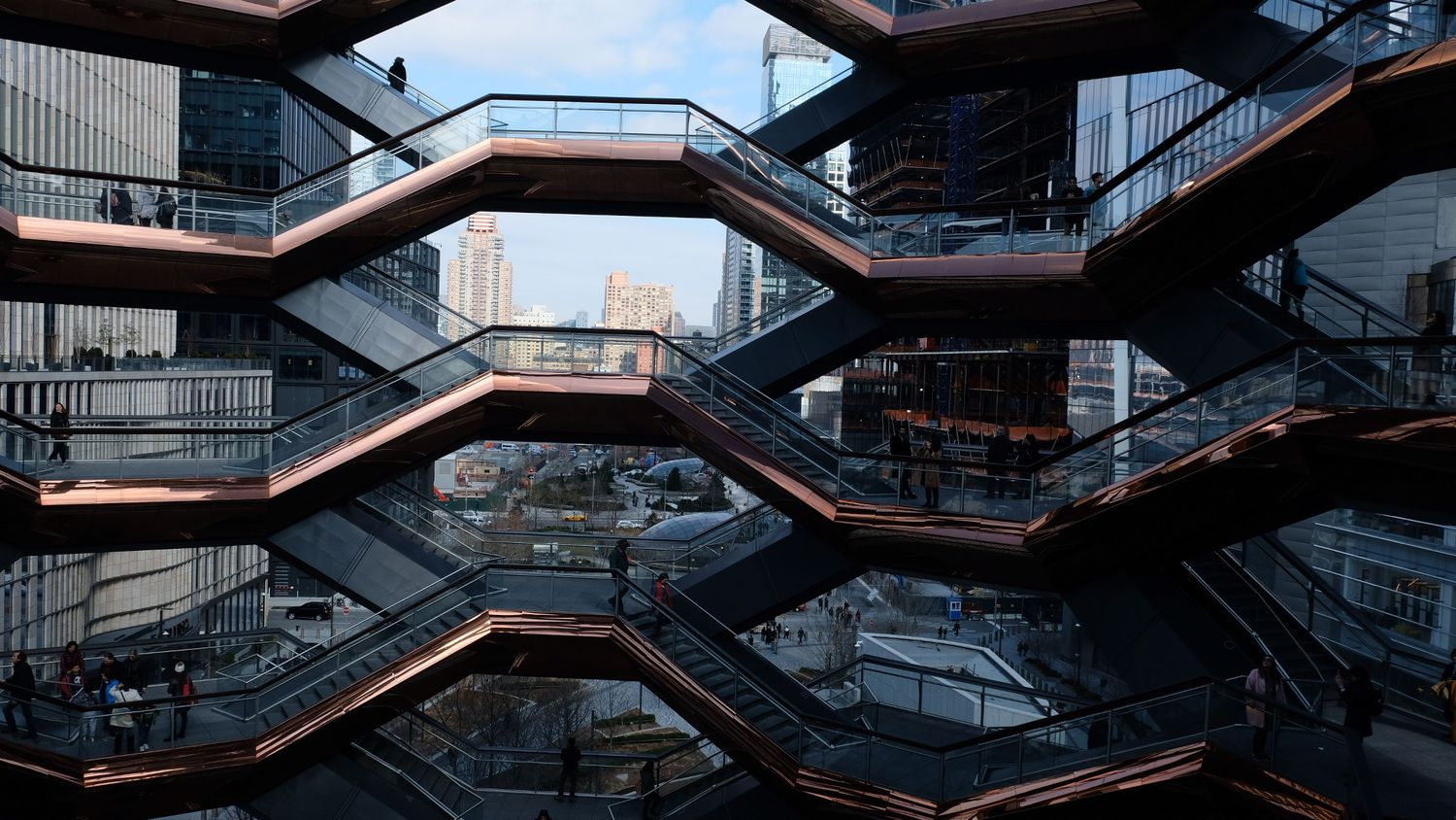 The intricate honeycomb-like copper and steel staircases of the Vessel landmark in Hudson Yards, NYC.