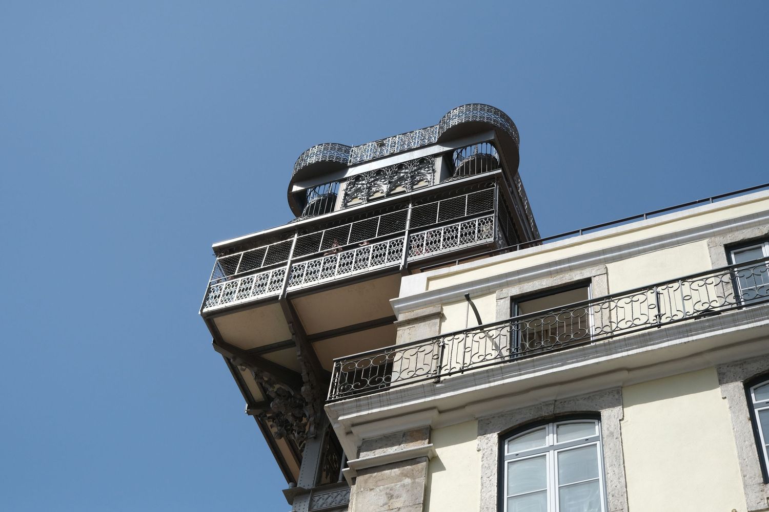 Top section of the ornate Santa Justa Lift with wrought iron details and viewing platform in Lisbon.