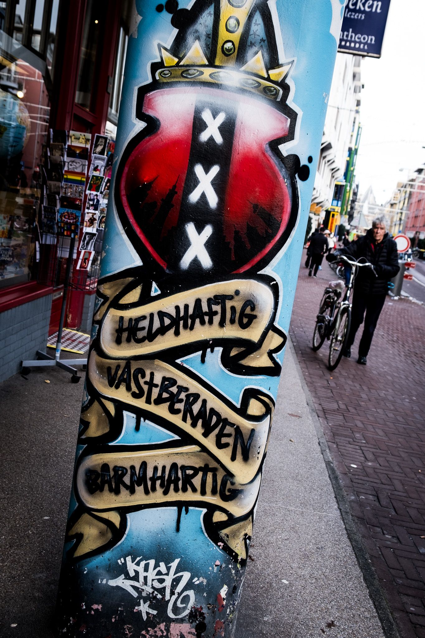 Amsterdam street graffiti mural featuring city coat of arms with Dutch words Heldhaftig, Vastberaden, Barmhartig.