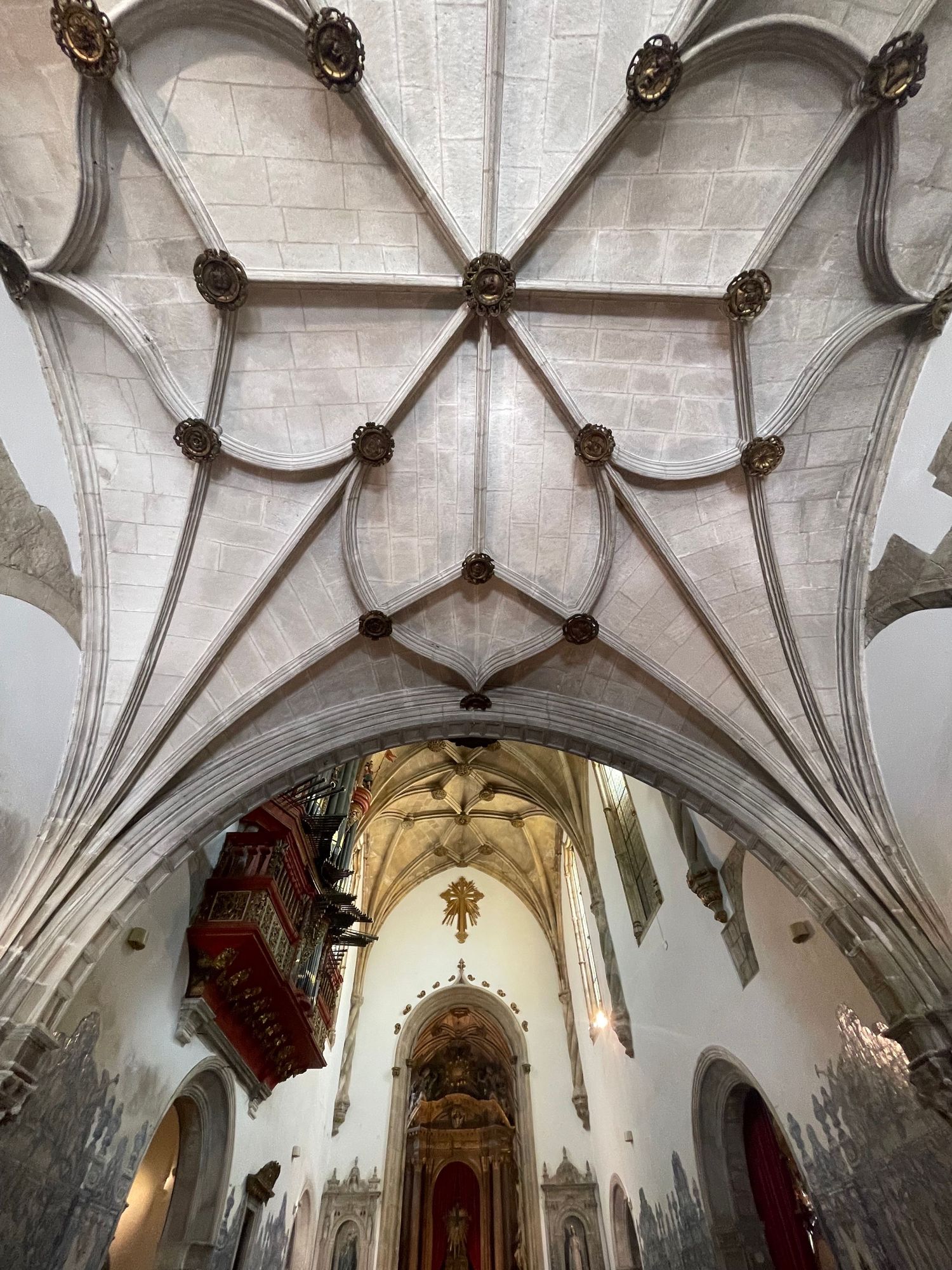 Stunning Gothic ribbed vaulted ceiling of a historic Portuguese church with ornate stone carvings.