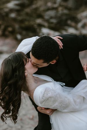 A romantic couple in white clothing share intimate kisses in a series of connected photos.