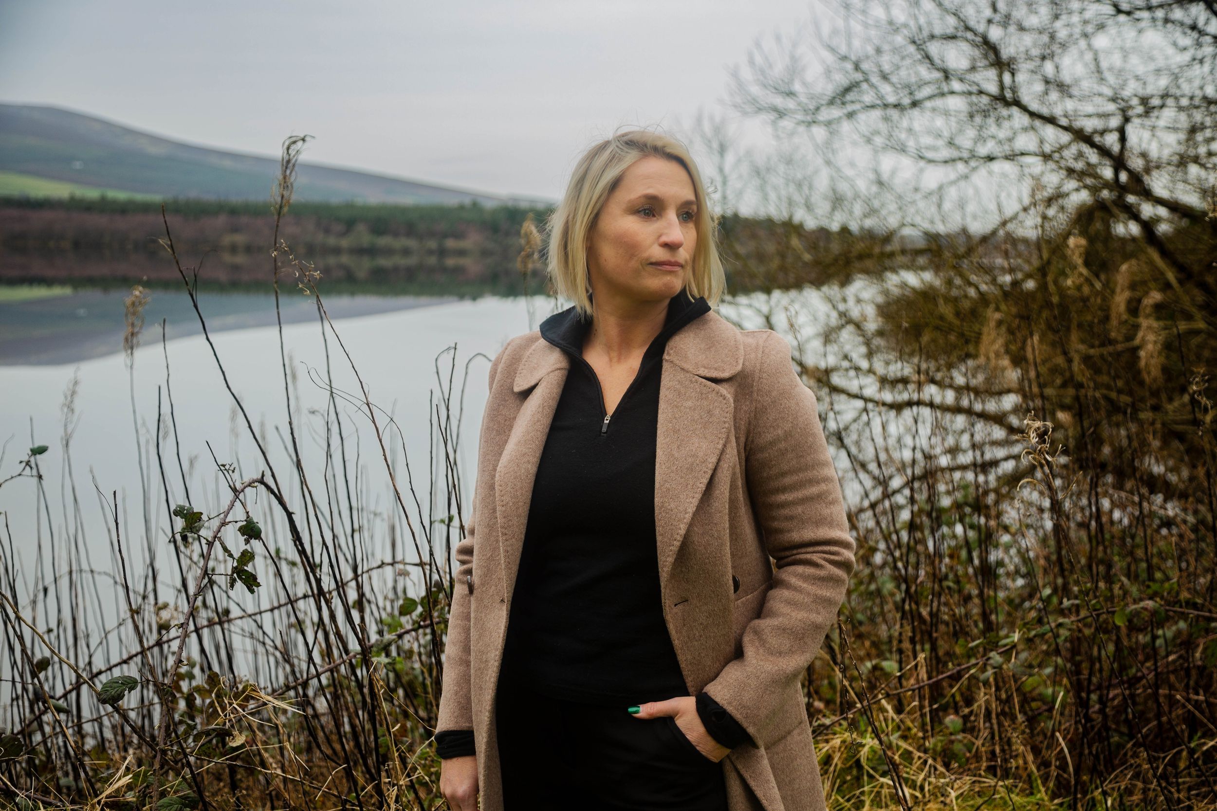Scenic lakeside photo shoot featuring picturesque mountains and autumnal plants.