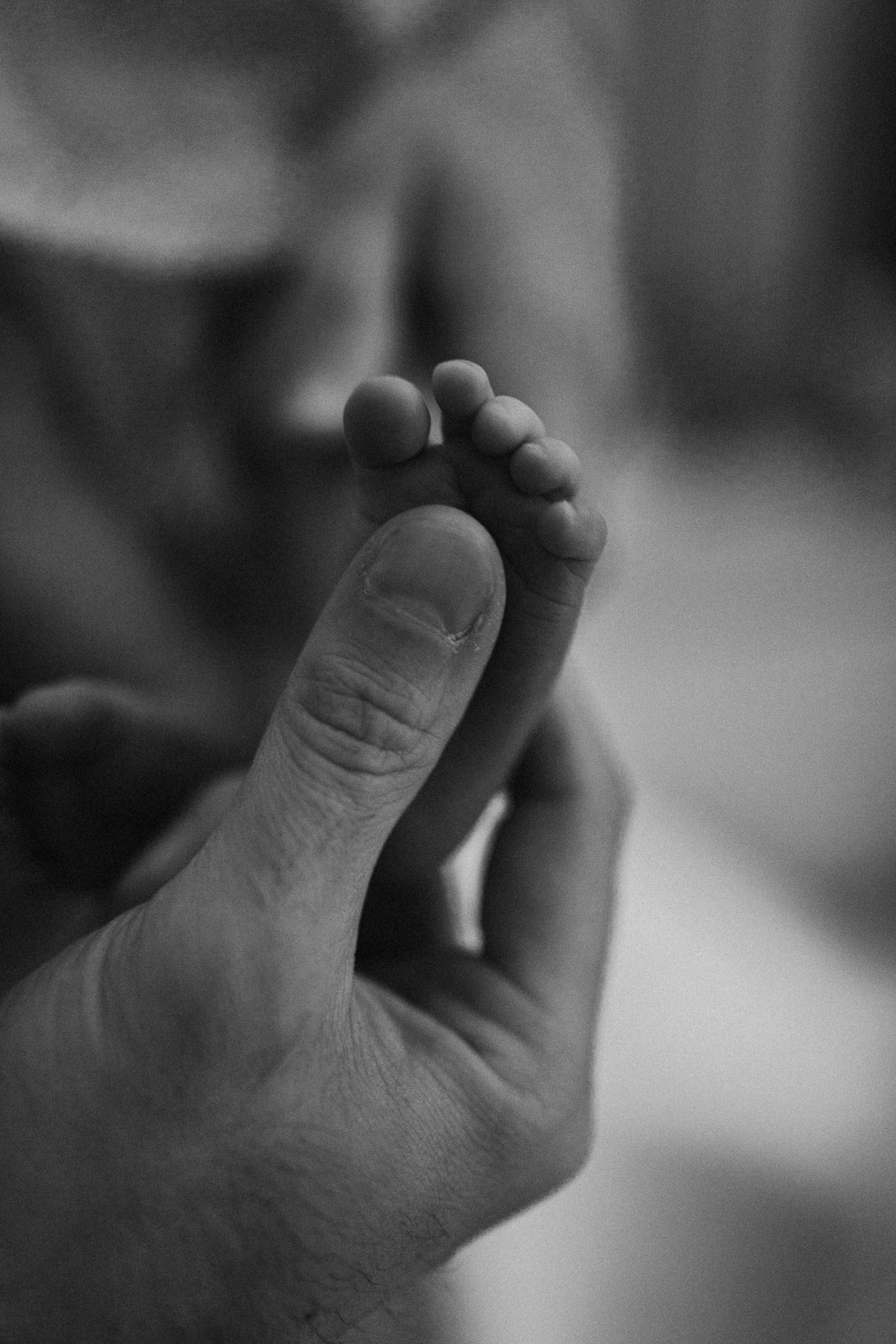 A new mom with an infant during a lifestyle newborn session at home.