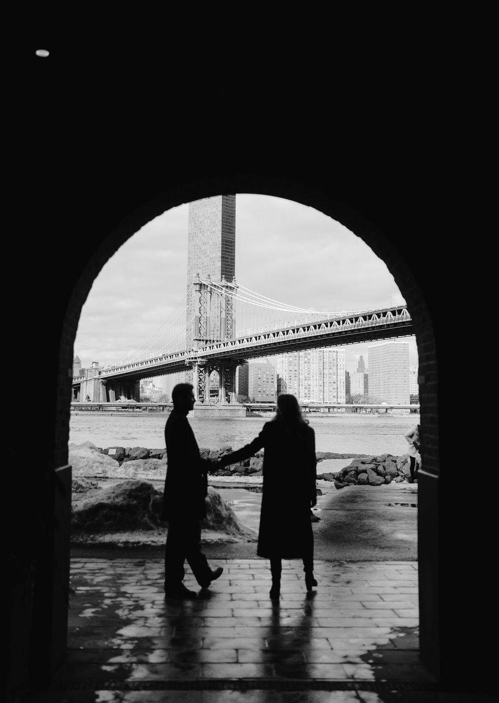 Silhouetted figures stand in an archway with the Golden Gate Bridge visible in the background through multiple frames.