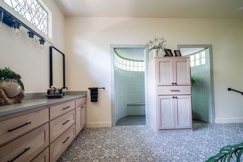 Spacious bathroom interior with wood vanity, built-in storage cabinet, and curved architectural details.