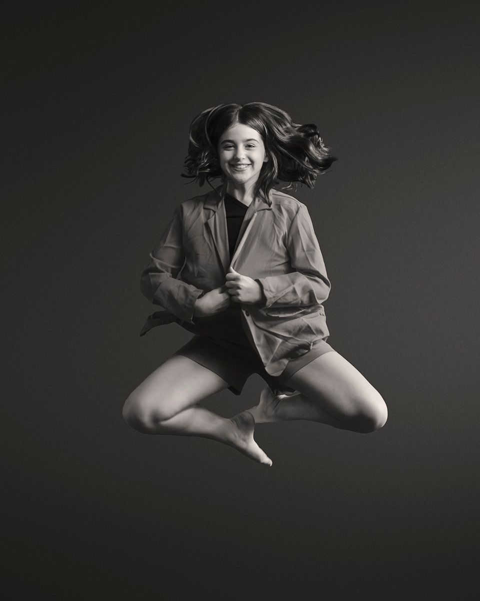 A series of dynamic dance poses captured in black and white against a dark background shows graceful movement and form.