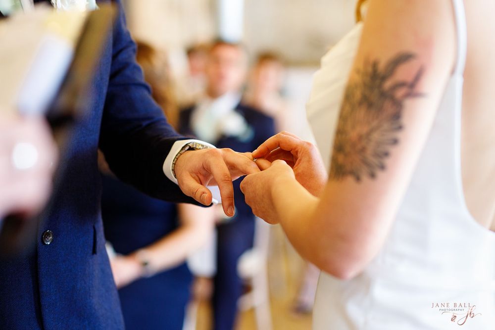 Wedding guests dance and celebrate on a sunlit dance floor during a reception.