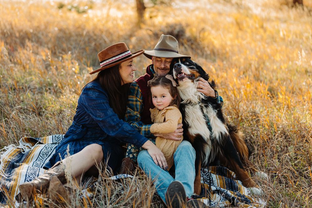 A couple shares tender moments together in a golden autumn field during sunset.