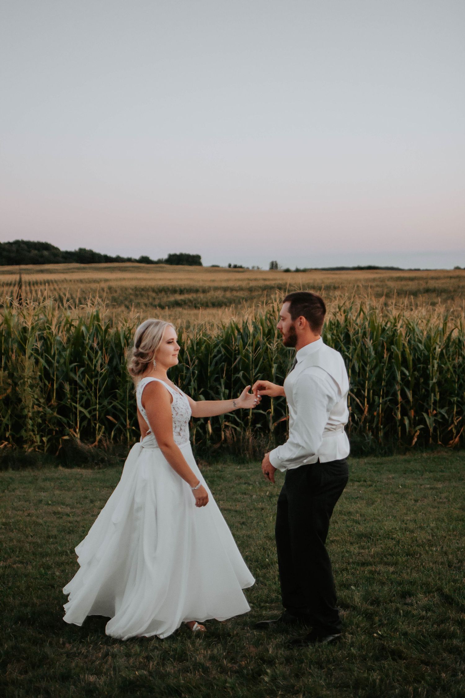 Bride and Groom dancing in wheat field in Wisconsin at their farm and barn wedding.