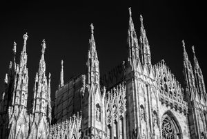 Multiple views of Milan Cathedral's ornate Gothic architecture in high contrast monochrome.