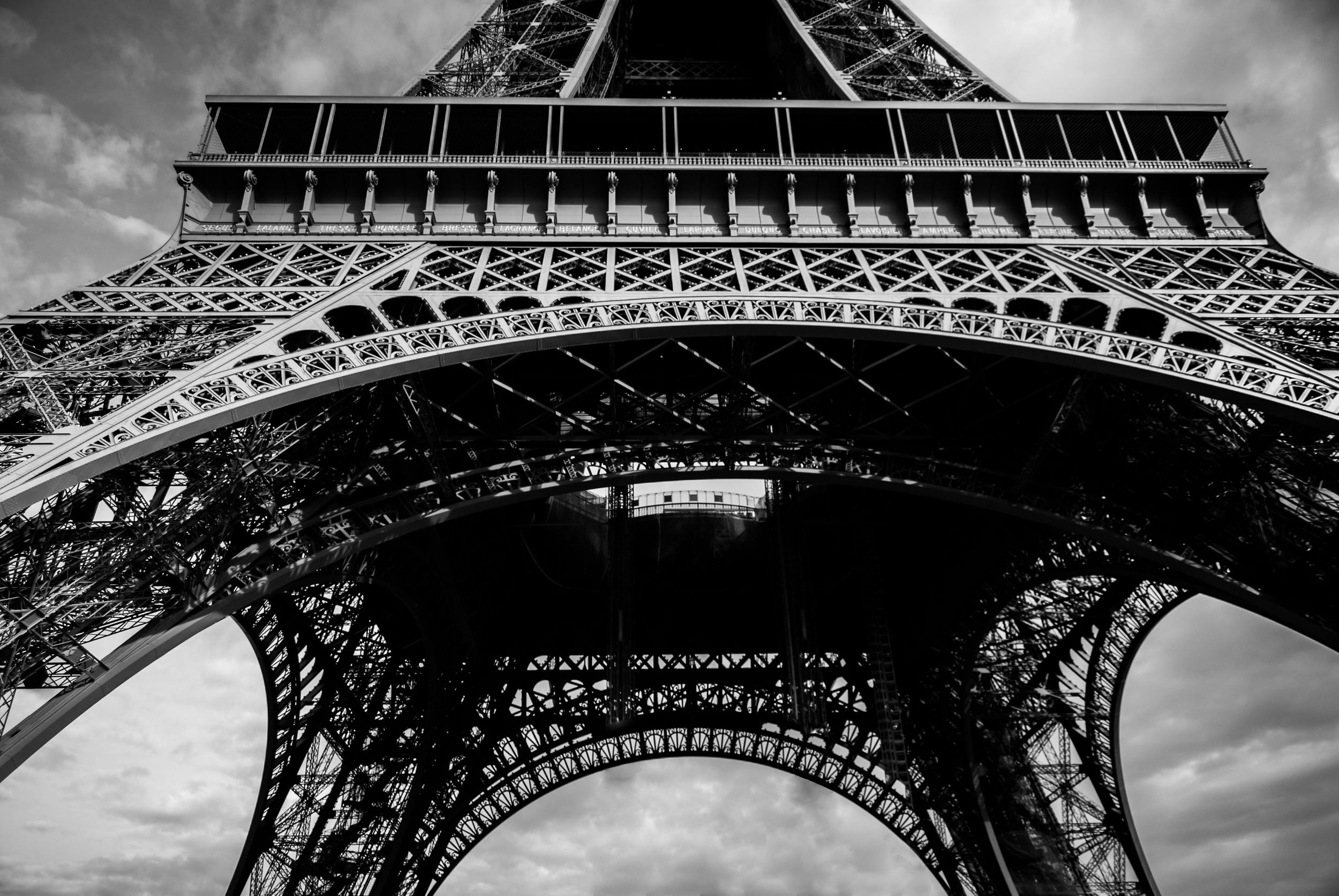 Panoramic black and white photo sequence of the Eiffel Tower in Paris showing different angles and perspectives.