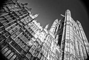 Low angle black and white architectural shot of Westminster Abbey's Gothic spires reaching towards the sky.