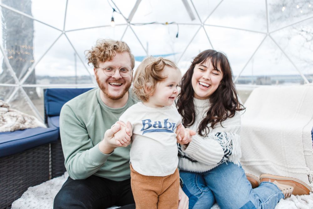 A joyful family shares a warm laugh together while sitting on an outdoor patio couch.