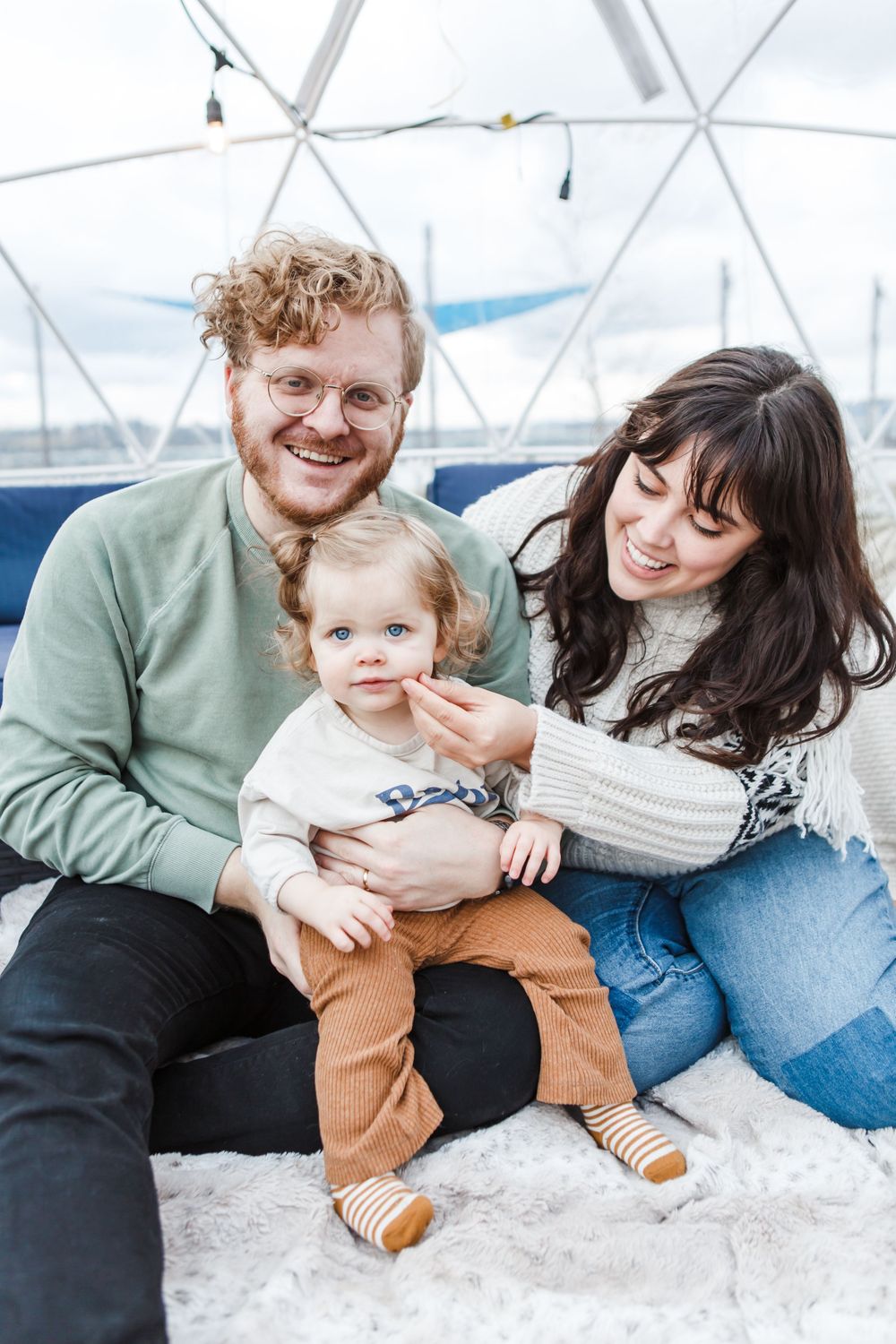 A loving family embraces and plays together on a white blanket in a candid photo sequence showing joyful moments.
