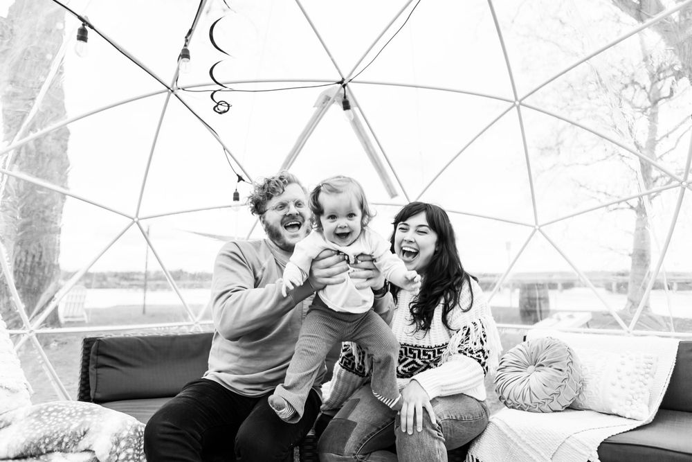 A group enjoying a cozy moment together inside a geodesic dome structure in black and white.