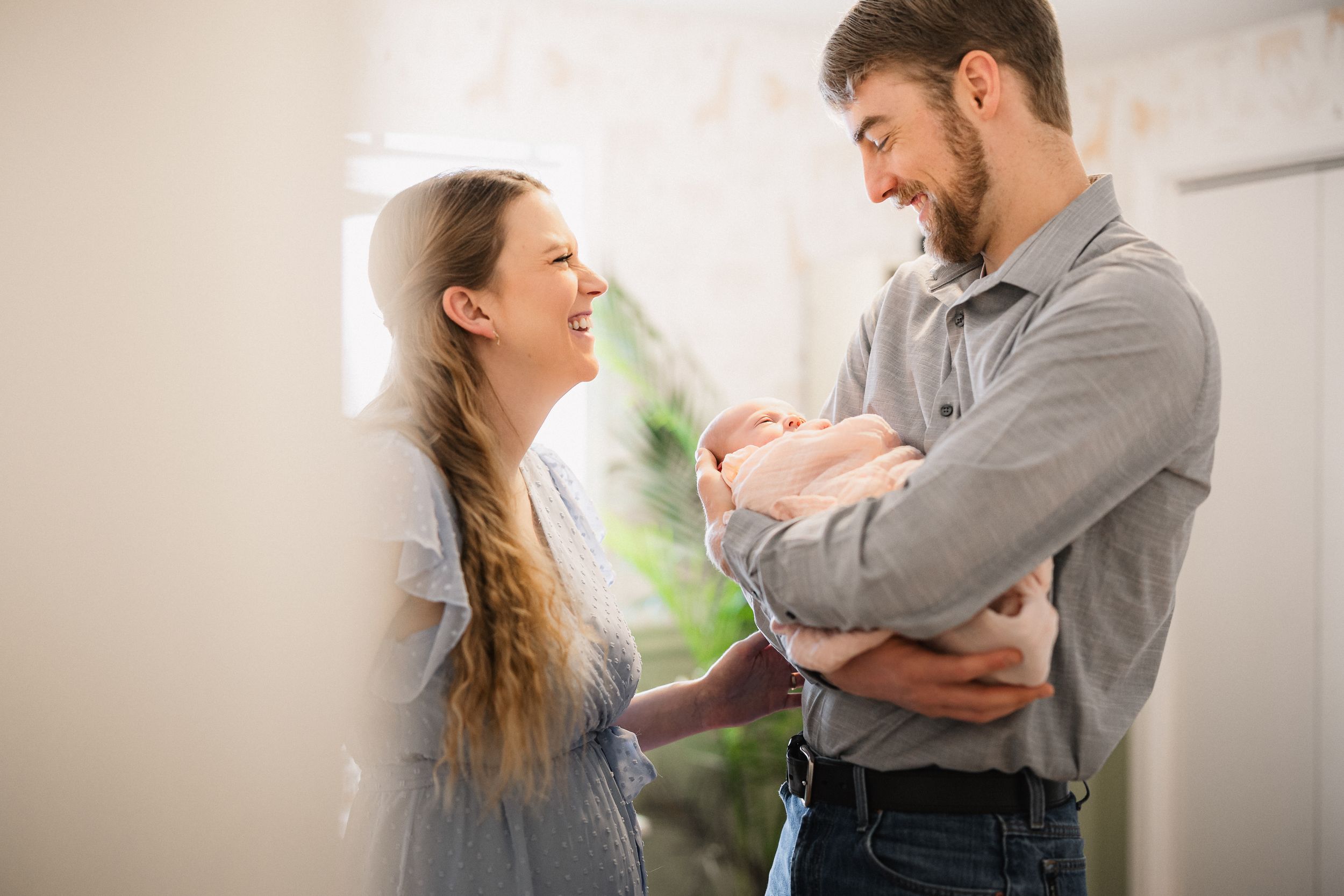 A couple shares tender moments in a series of candid lifestyle photos in a bright, minimal interior space.