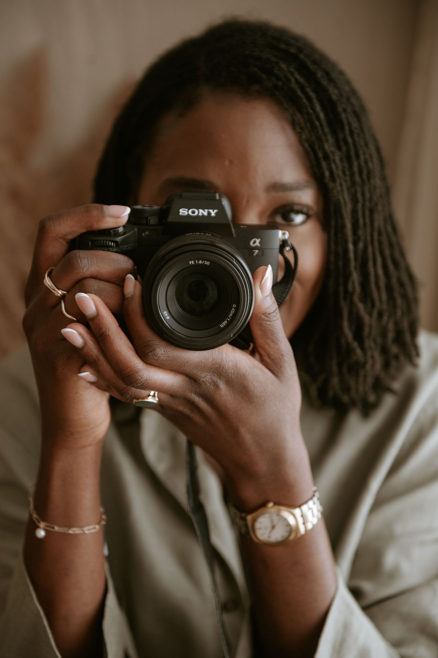 Black female photographer specialising in maternity, newborn and family photography, holding a camera