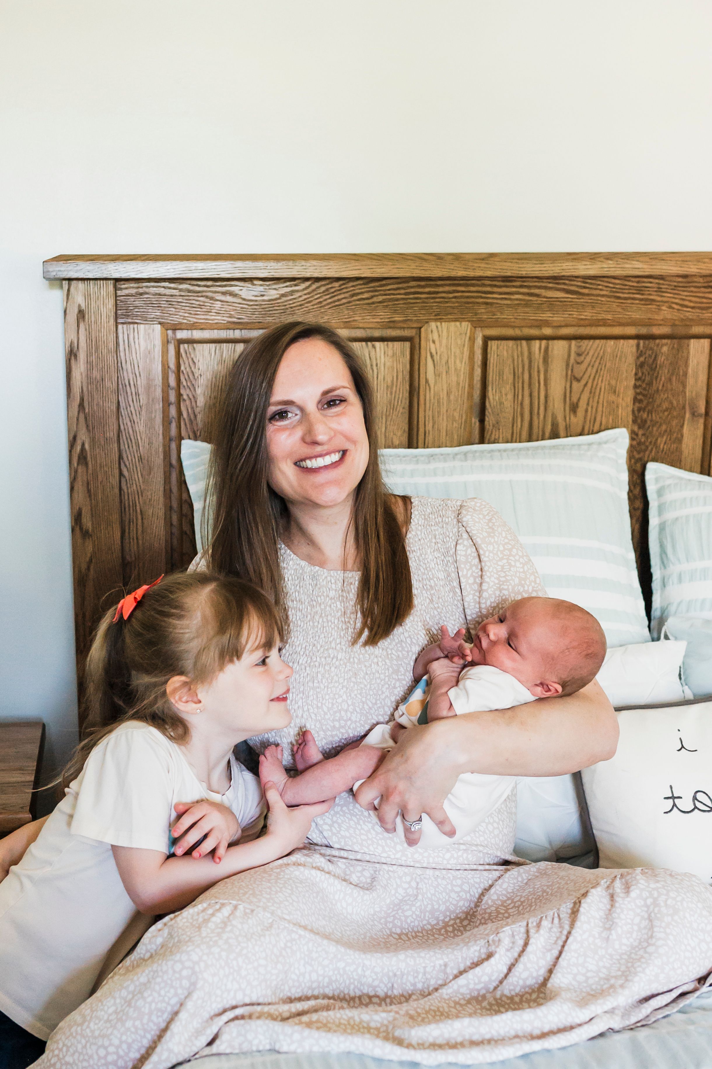 A tender family moment of bonding with a newborn baby in a cozy bedroom setting.