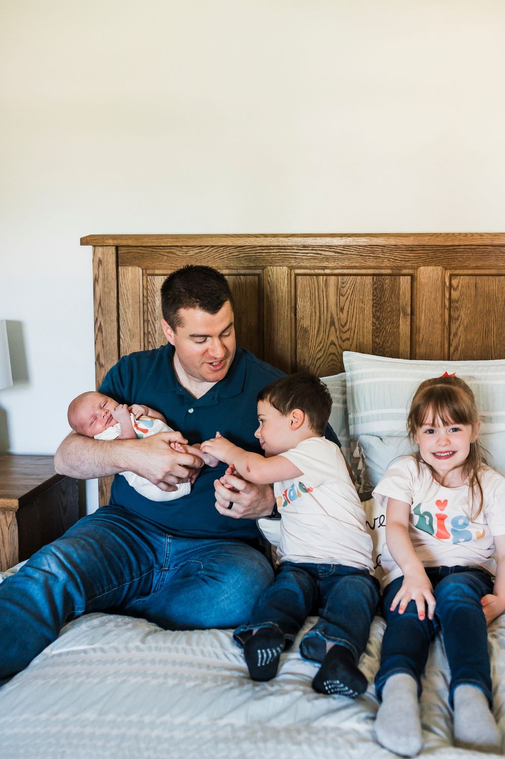Candid lifestyle photography series shows sweet playful moments between family members relaxing on a cozy white bed.