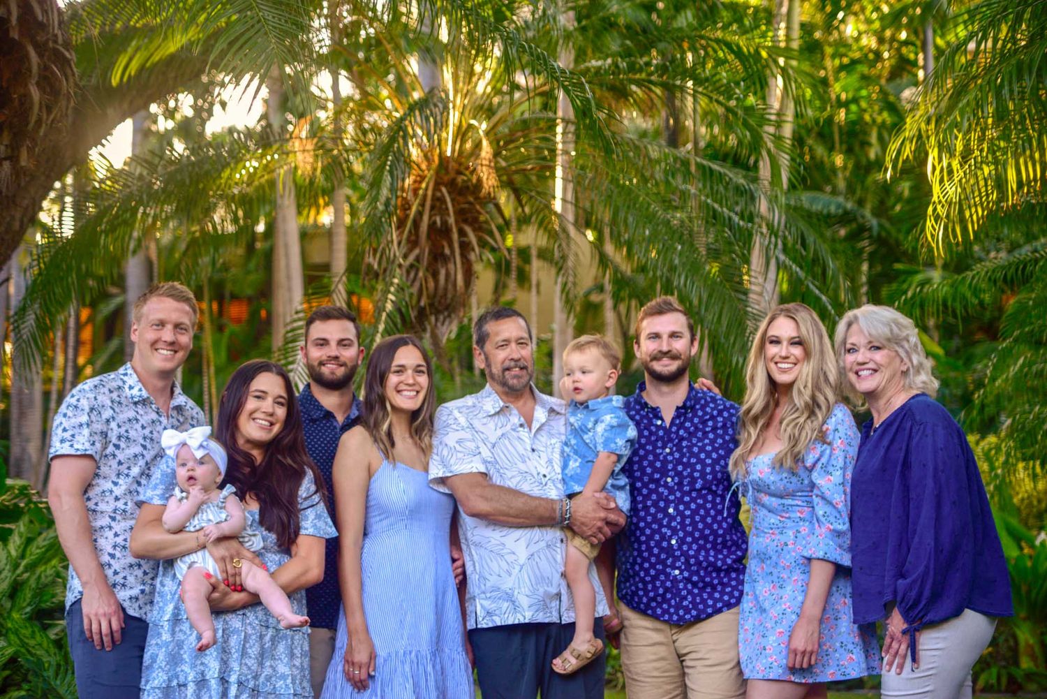 Taken in Waikiki in Fort De Russy park. A large multi-generational family poses together outdoors among lush tropical greenery for photos.