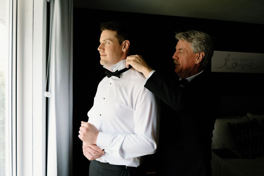 Dark interior room with window light illuminating formal attire preparations.