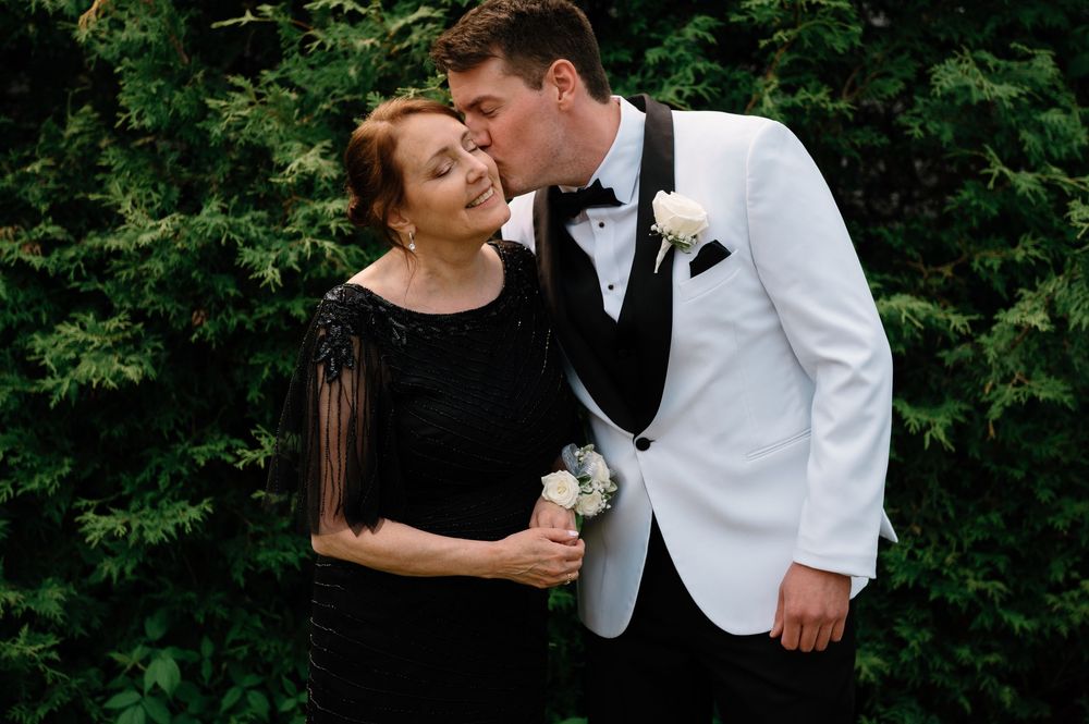 A romantic moment captured between a couple in formal wear against greenery.