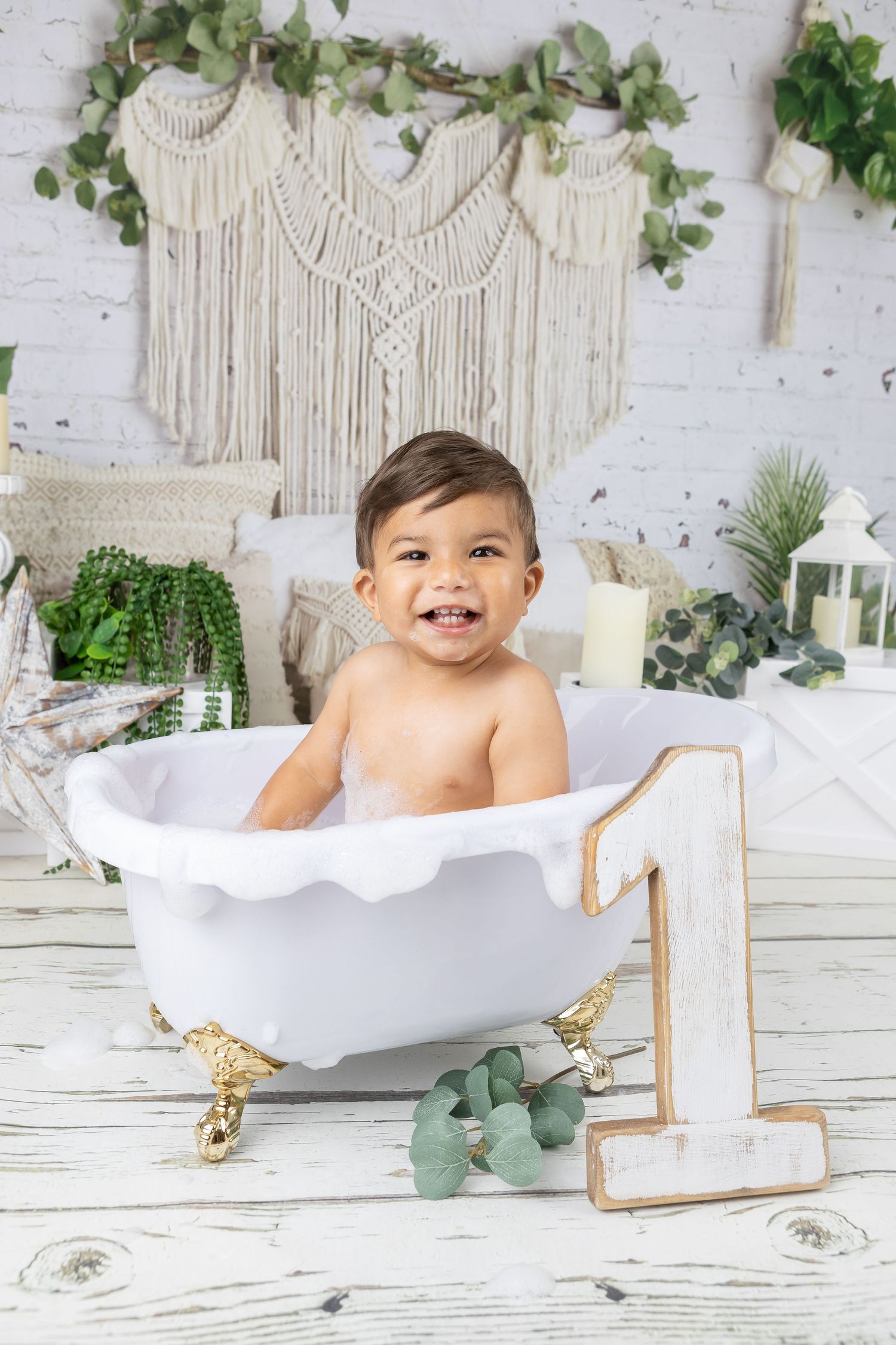 Boho themed bath session with macrame backdrop and greenery decorations.