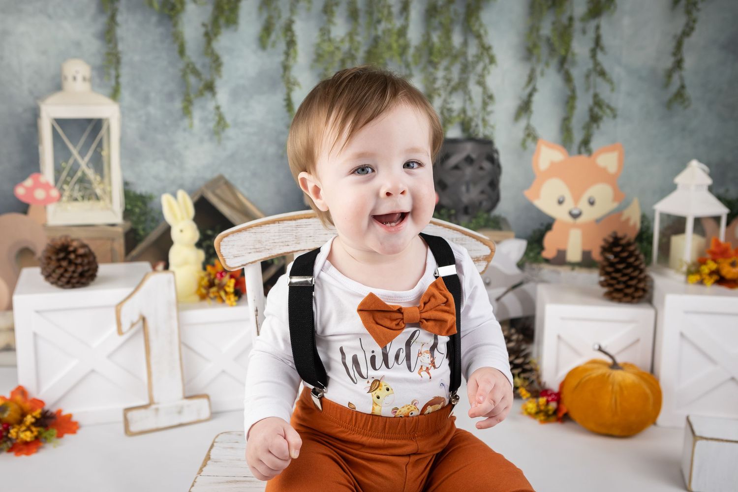 Fall themed milestone photo session with pumpkins and rustic decorations.