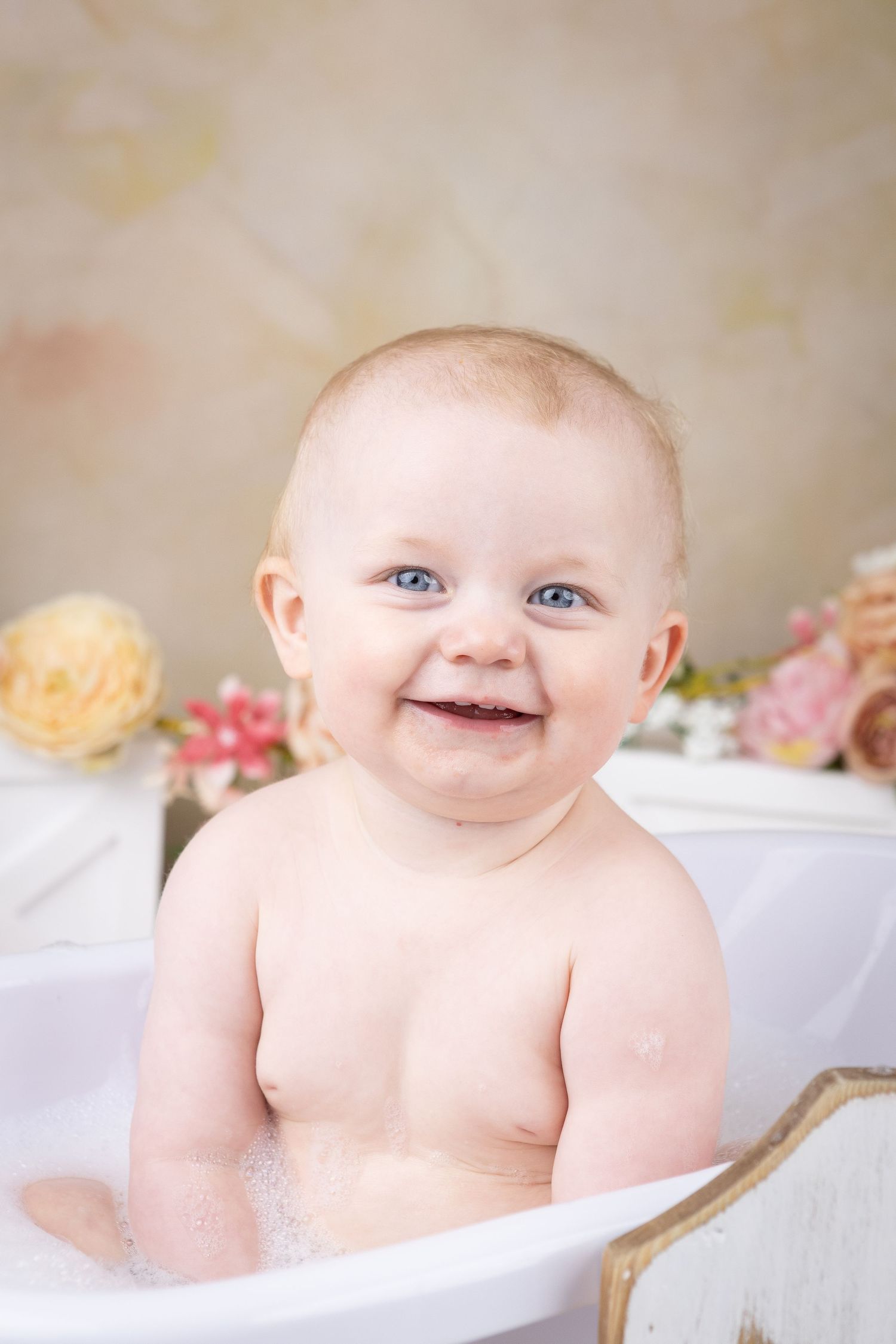 Vintage style milestone bath session with soft lighting and floral accents.