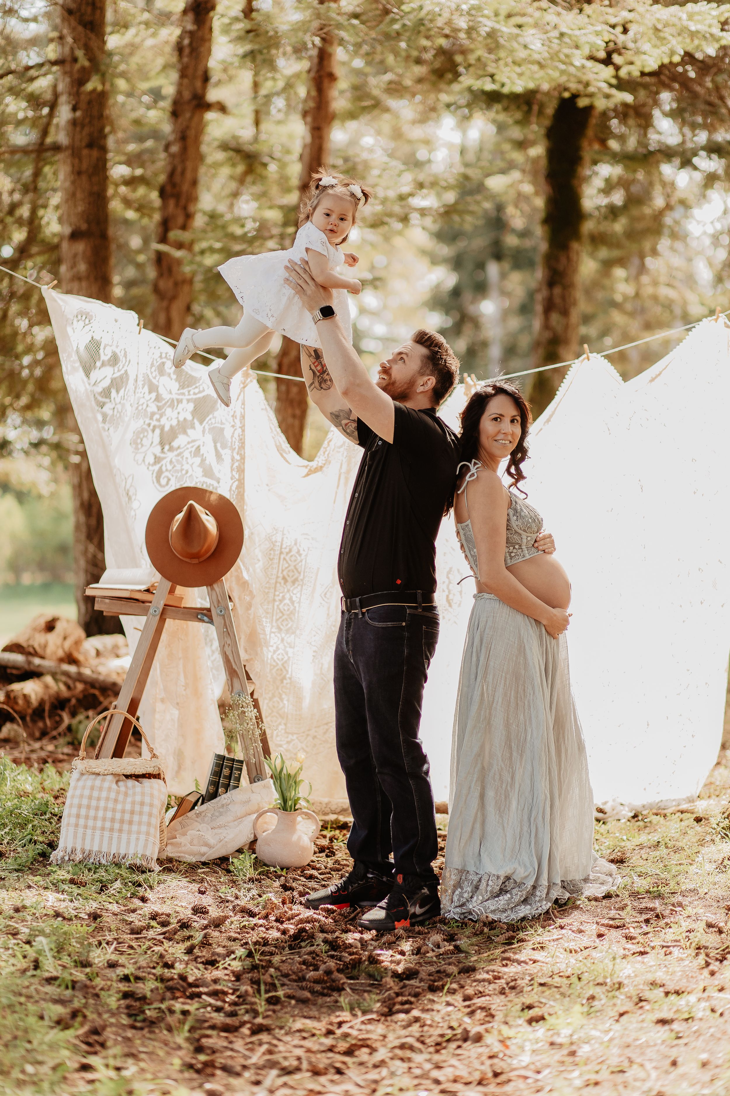 Laundry hangs on clotheslines between trees in a whimsical outdoor photoshoot setting.