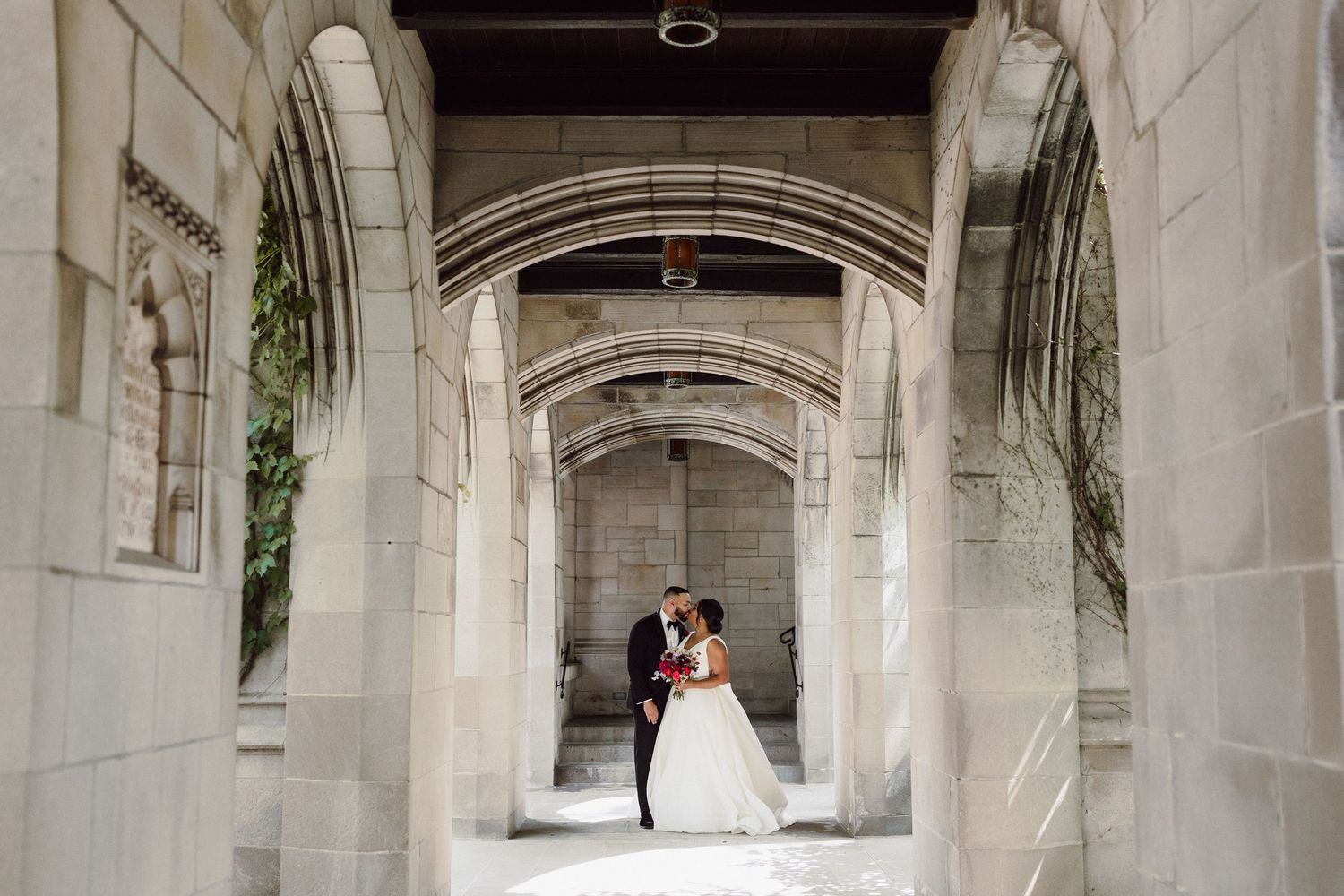 Wedding couple photographed in sequence under historic stone colonnade.
