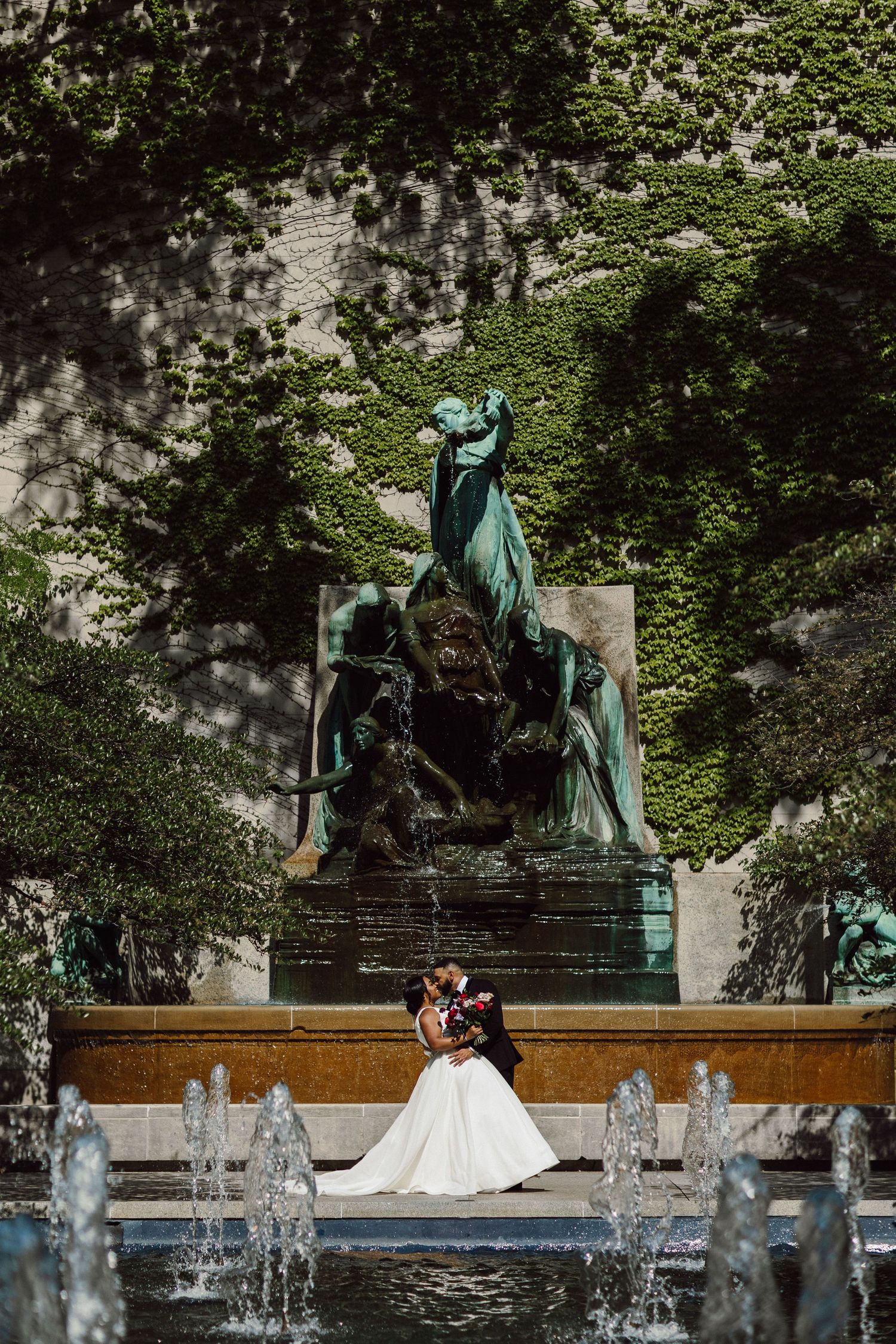 Wedding portraits captured near garden fountains and bronze sculptures.