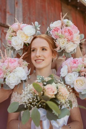 Beautiful floral arrangements featuring pink and white roses with eucalyptus and baby's breath against a rustic background.