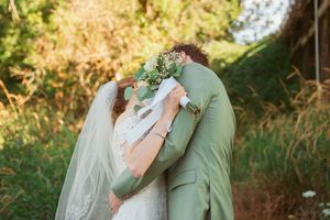 Close-up wedding portrait showing delicate details of bridal bouquet and mint green attire.