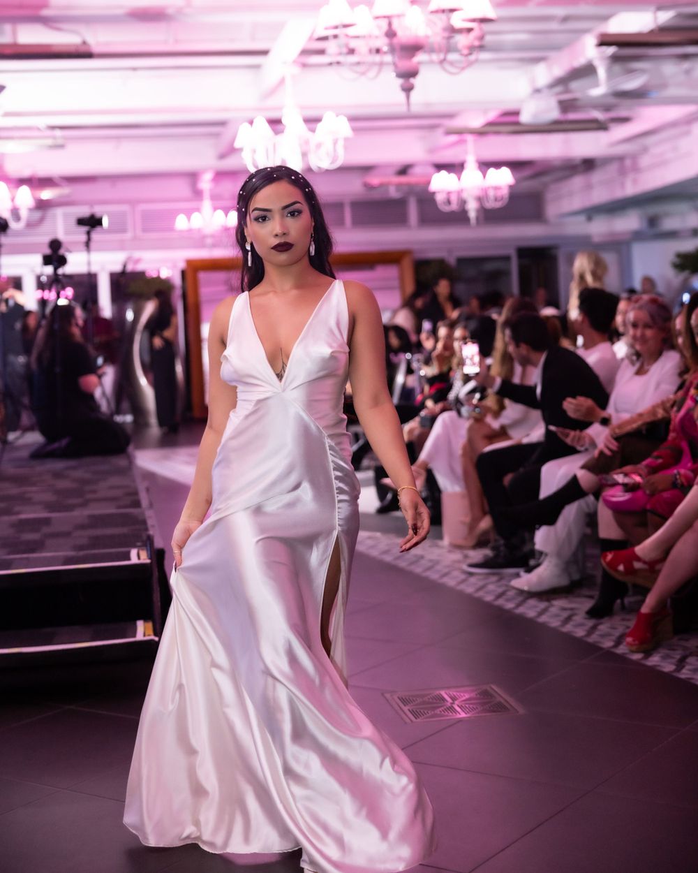 White satin mermaid gown with deep v-neckline presented at evening fashion show.