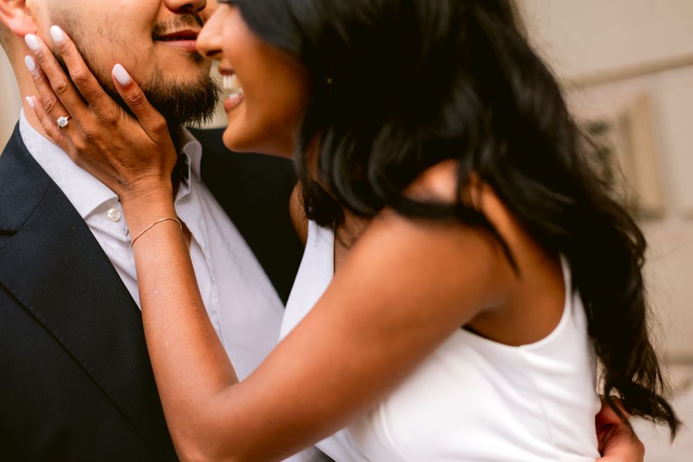 Intimate moment between couple in formal attire sharing laughter and embrace.