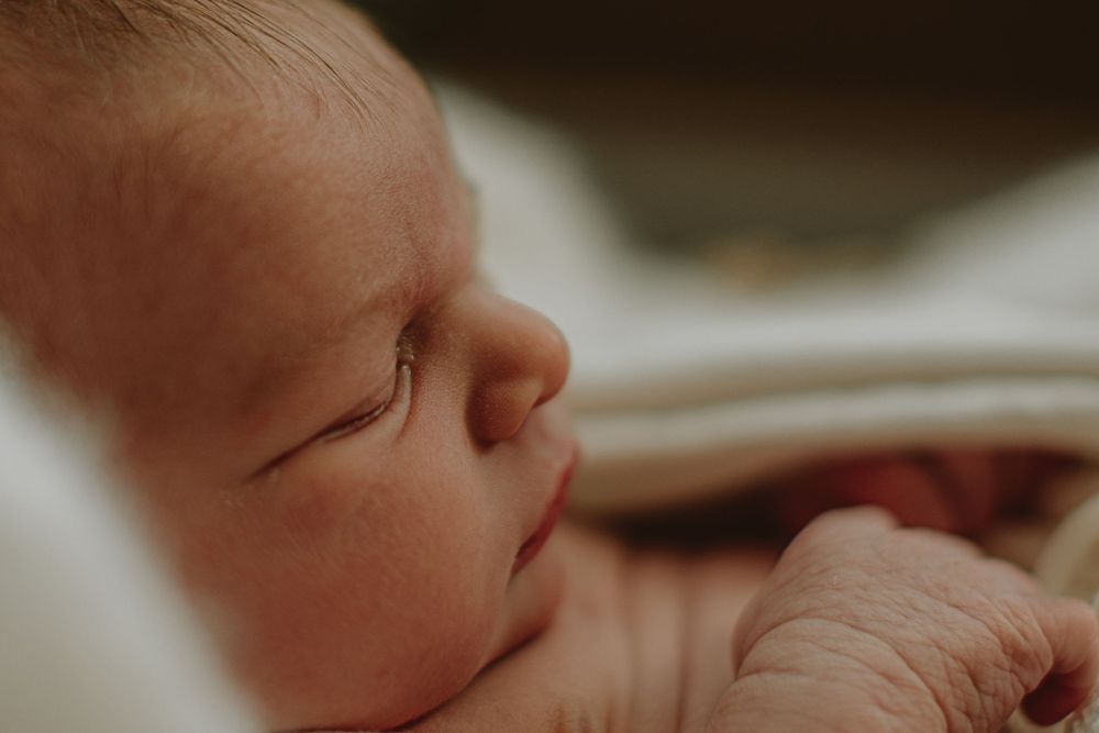 Close-up macro shot of newborn baby details in soft lighting.