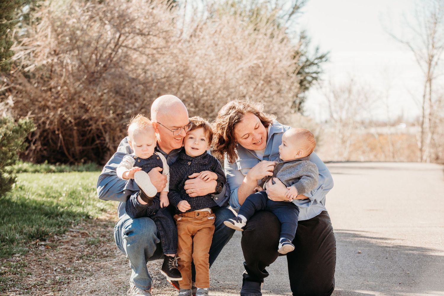 Playful outdoor family portrait with small children on a sunny day.